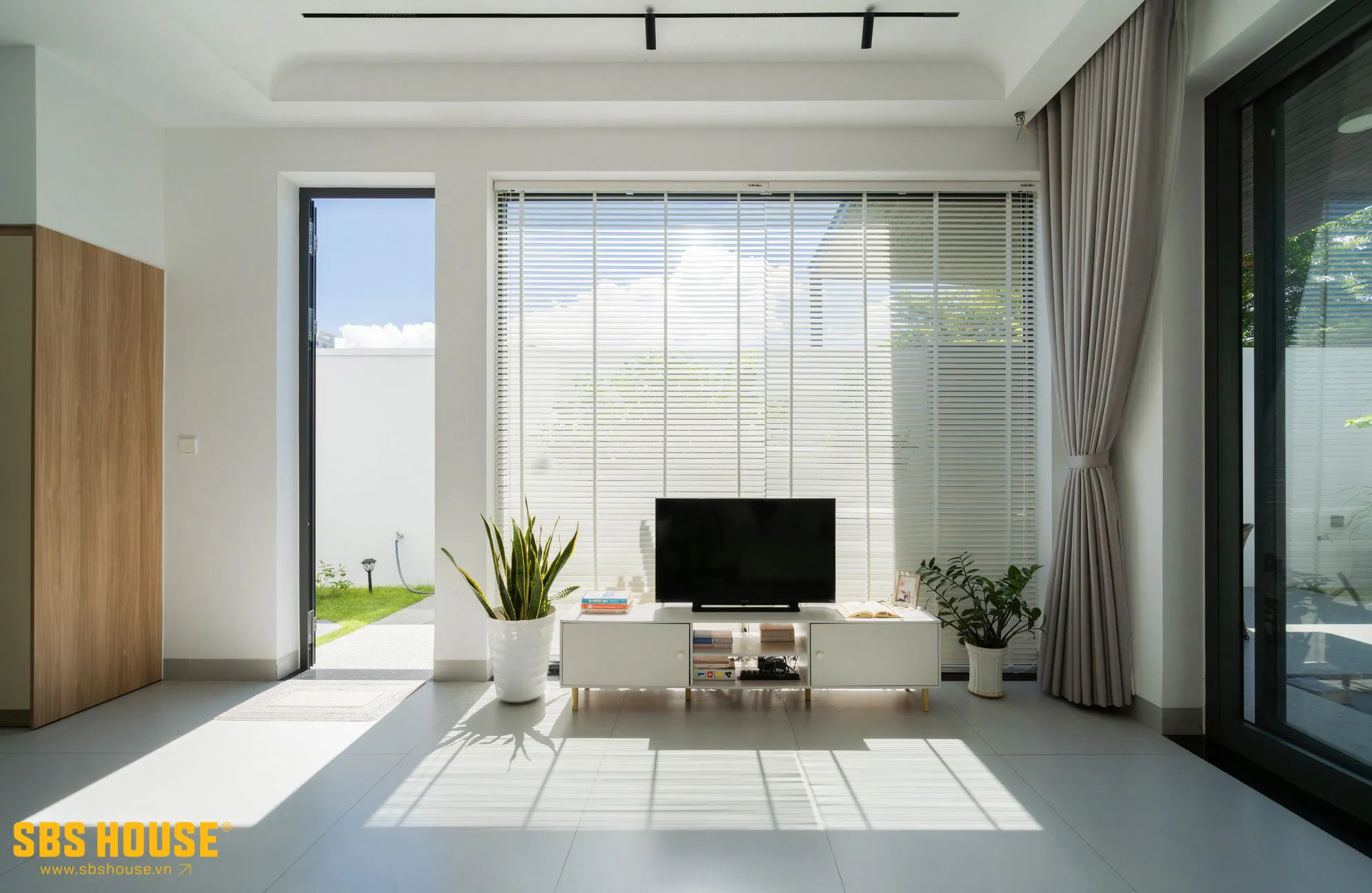 S's House được thiết kế với vách kính ở phòng khách hướng không gian mở ra khoảng sân và cây xanh.