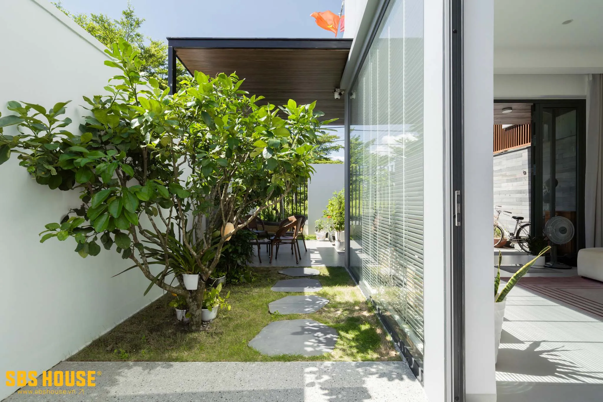 Khoảng sân vườn cạnh nhà với cây xanh tươi tốt.