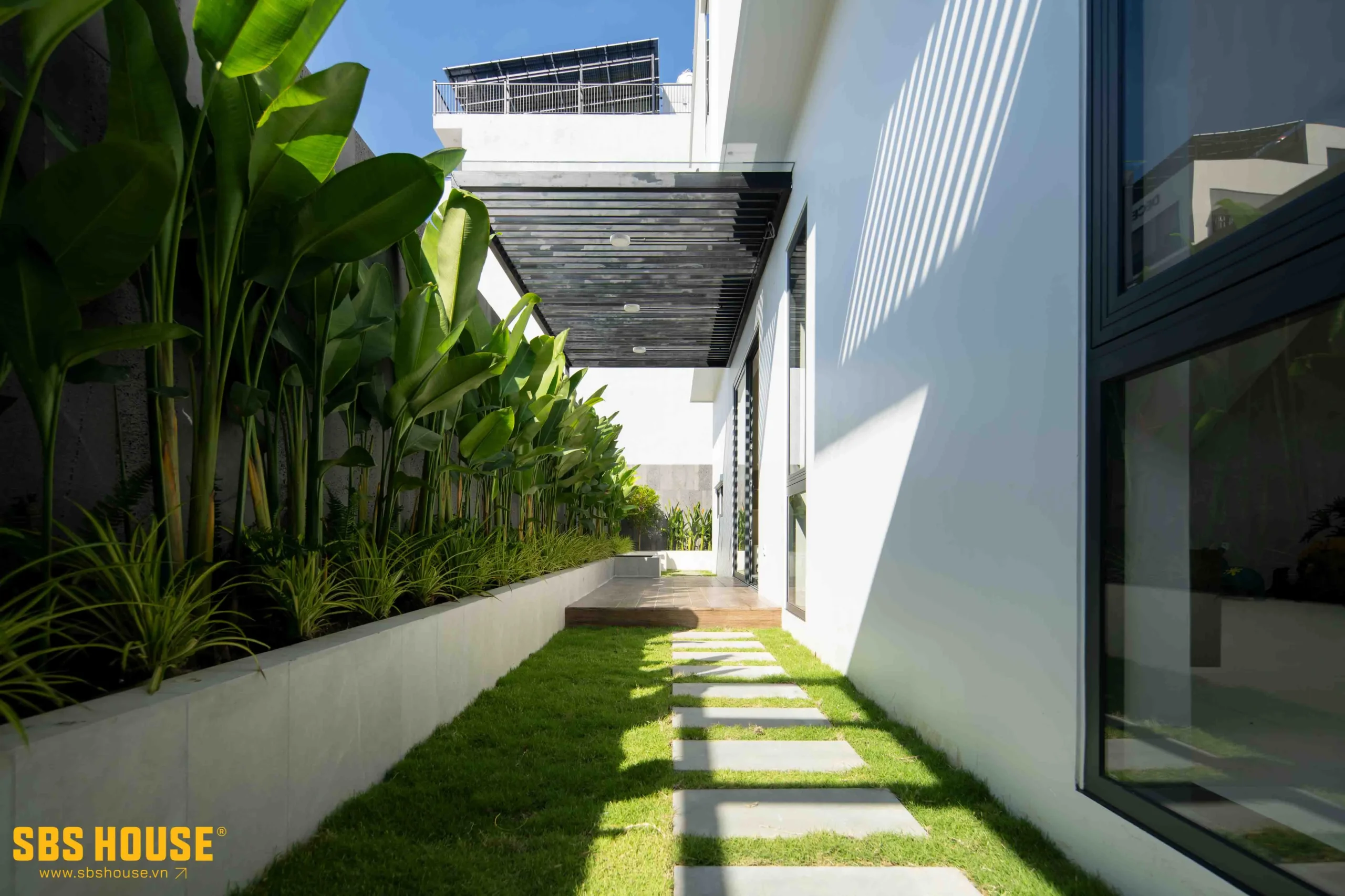 Một lối đi bên hông nhà ngập tràn cây xanh.